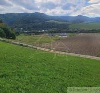 Countryside landscape, meadow, roads and gardens under mountains and clouds in the sky.
