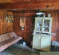A wooden interior of a cabin with a couch, cabinet, and decorations, an ideal place for a family home.