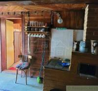 Wooden interior with a stove, shelf, chair, and door in a family house.