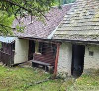 A family house with a wooden porch surrounded by nature, suitable for a peaceful country life.