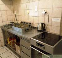 A kitchen with a stove, deep fryer, and electric kettle, ideal for a cottage.