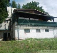 The picture shows an older cottage surrounded by nature, ideal for relaxation.