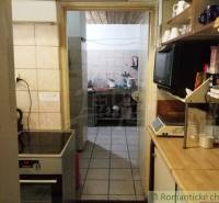 A kitchen in a cottage, wooden shelves, stove, kitchen equipment. Romantic cottage atmosphere.