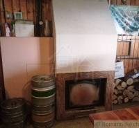 Interior with a fireplace, beer barrels, and wood, ideal for relaxing in a cabin.
