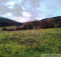 The image depicts a natural landscape with agricultural and forest lands.