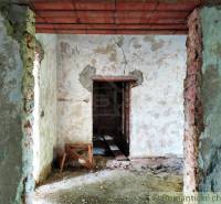 Interior renovation of a family house with exposed brick walls and damaged plaster.