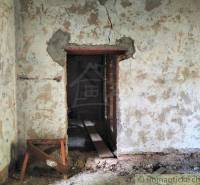 The image shows a neglected interior of a family house with old plaster and a wooden support.