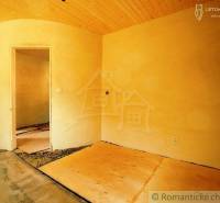 Rooms of a family house with a wooden ceiling and clay walls without flooring.