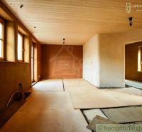 Family house with a wooden ceiling and clay plaster, large windows for natural light.