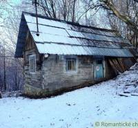 A wooden cabin in a snowy landscape hidden among trees, ideal for a romantic getaway.