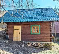 A wooden cabin with a blue roof surrounded by nature, ideal for a weekend getaway.