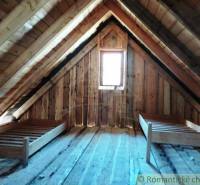 Attic cabin, wooden walls and ceilings, simple beds, cozy space for relaxation.