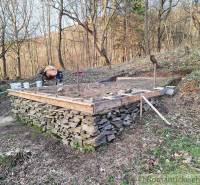 Foundations for a cabin built from rocks in the forest, construction process against the backdrop of nature.
