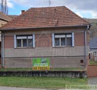 Older family house with a red roof for sale in a quiet village setting.