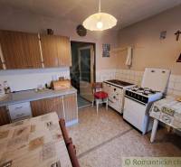 A kitchen with a gas stove and kitchen cabinets in a country house.