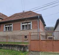 A family house with a gable roof, fence, brick facade, in a quiet location.