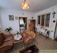 Living room of a family house with wicker furniture, flowers, and traditional decorations.