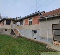 A family house with a red roof has a satellite dish installed on the facade.