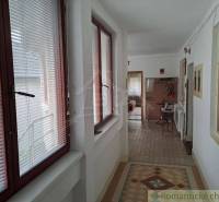 Family house with a hallway equipped with windows with blinds and tiles.