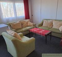 Living room with sofas, a table, and curtains, suitable for commercial spaces.