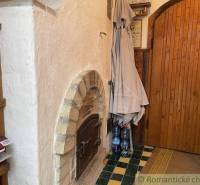 Traditional brick oven, wooden shelves with items, rustic cottage awaits discovery.