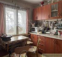 Kitchen in the **cottage**: dining table, chairs, kitchen unit, utensils, sink, containers on the window.