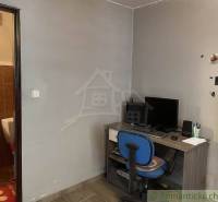 A desk with a computer, chair, bathroom; family house and study corner.