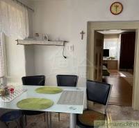 Dining area with a glass table and chairs in a cozy family house.