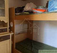 Wooden bunk bed and cabinet in a rustic cottage, traditional elements and cozy atmosphere.