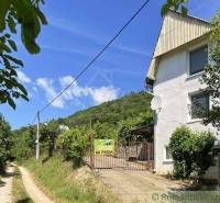A cottage near Rožňava with a view of the forest road and hilly terrain.