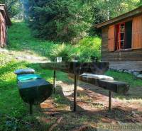 A cottage with wooden furniture and a peaceful atmosphere in a forest setting for relaxation.