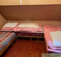 A cottage with antique furniture, simple beds, and wooden flooring, ideal for relaxation.