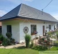 A family house in nature, with a white facade, a garden, and rustic decor.