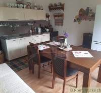 A kitchen in a family house with a wooden table, kitchen unit, and decorations.