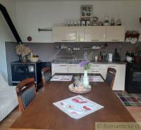 A kitchen in a family house with a wooden table, an antique stove, and decorations.