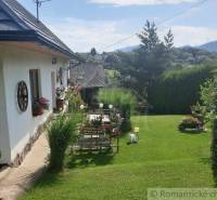 A family house with a garden, flowers, decorations, and dreamy views of the mountain peaks.