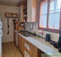 A kitchen with wooden elements, appliances, and a view from the window in a family house.
