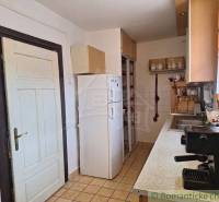 A kitchen in a family house furnished with kitchen furniture, appliances, and ceramic decorations.