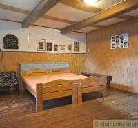 A bedroom in a family house with wooden furniture and wall decorations.