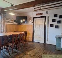 Interior of a family house with wooden furniture, an antique stove, and decorations on the wall.