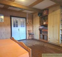 A room in a family house with a wooden floor, walls, and storage cabinets.