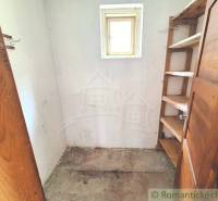 A small room with wooden shelves and doors, suitable for storage space in a family house.
