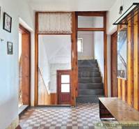 Entrance hallway in a family house with wooden paneling and a stone staircase.