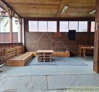 Wooden terrace with seating and a table in a family house, ideal for romantic cottages.