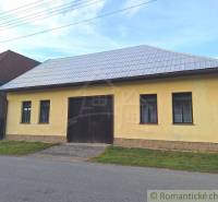 A yellow building with a metal roof, suitable for commercial spaces in a village environment.