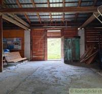 A light wooden garage with a bench and open doors offers rustic charm.