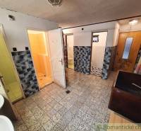 Entrance hall with several doors, tiles, and sinks. Commercial premises.
