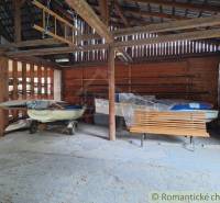 Wooden storage building with boats and a bench, suitable for vacationers and a family house.