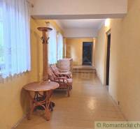 A hallway with yellow walls, rattan furniture, and curtains, ideal for commercial spaces.