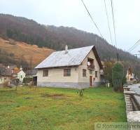 A traditional family house in a picturesque village with a beautiful mountain backdrop.
